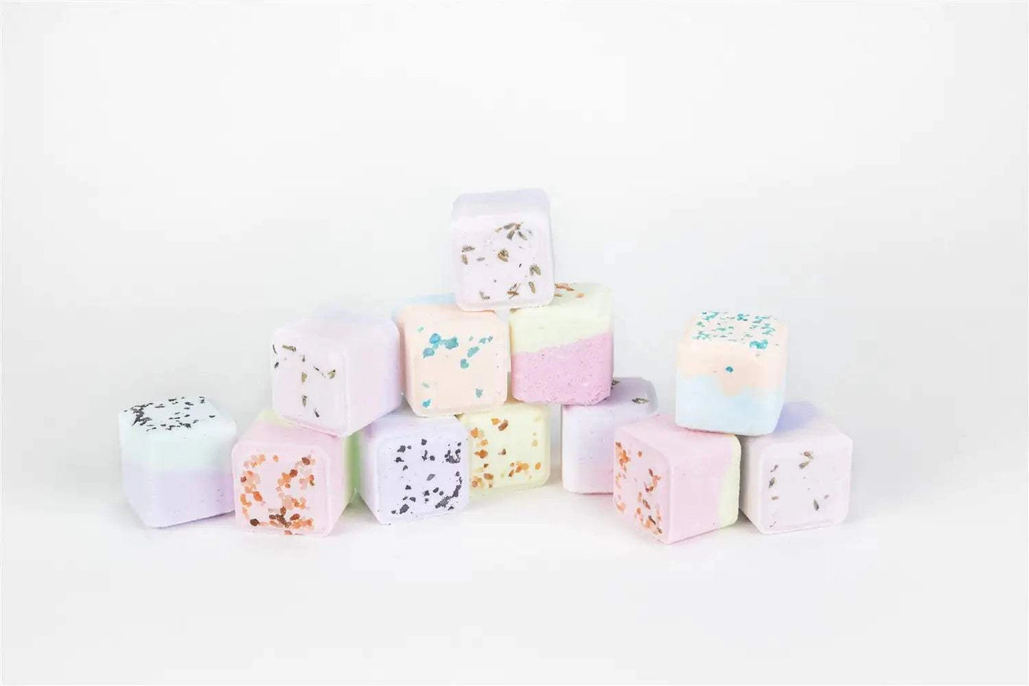 Colorful bath bomb cubes stacked in a pyramid for a celebration gift basket.