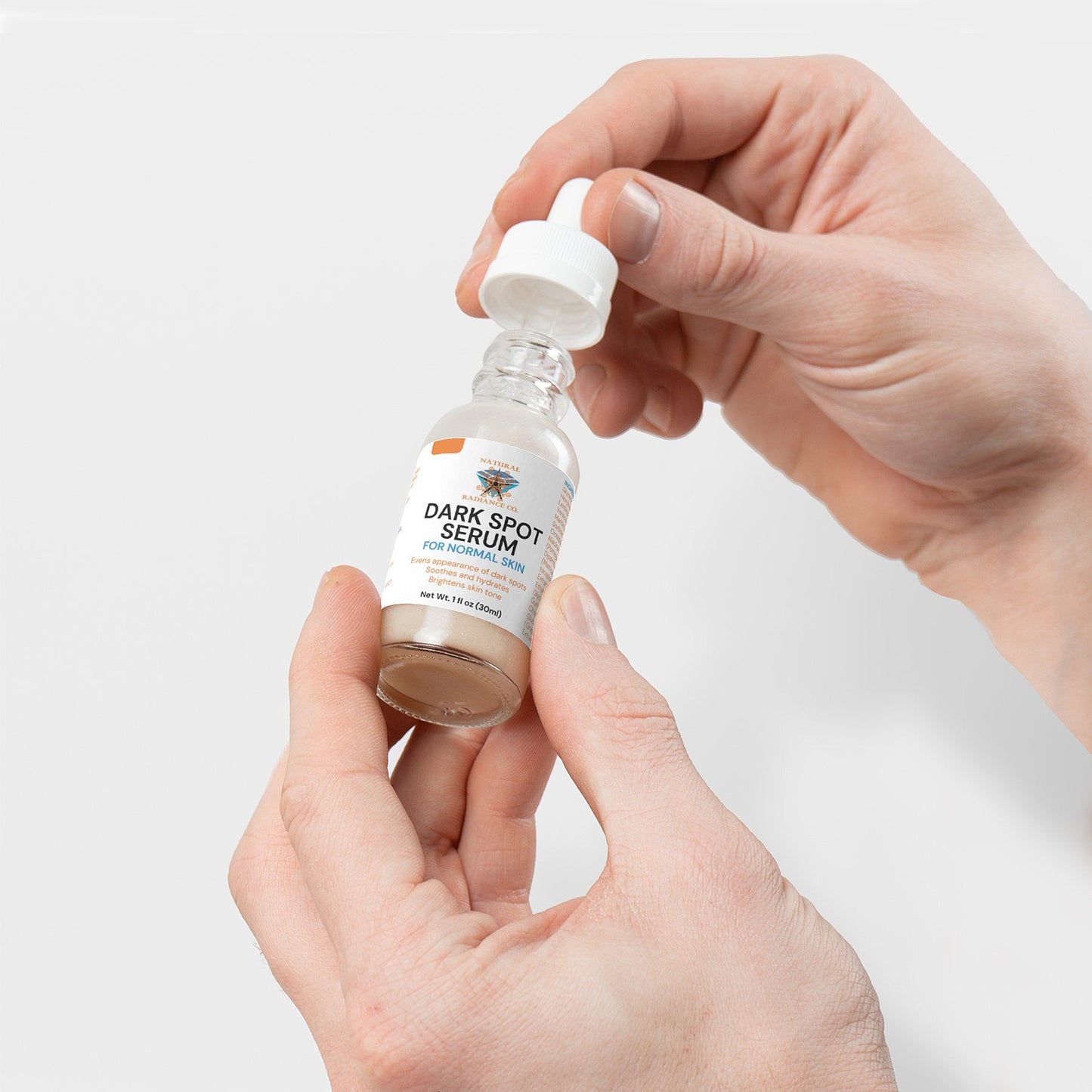 Dark Spot Serum for Normal Skin held in hands, featuring targeted elixir for radiant, even-toned skin.