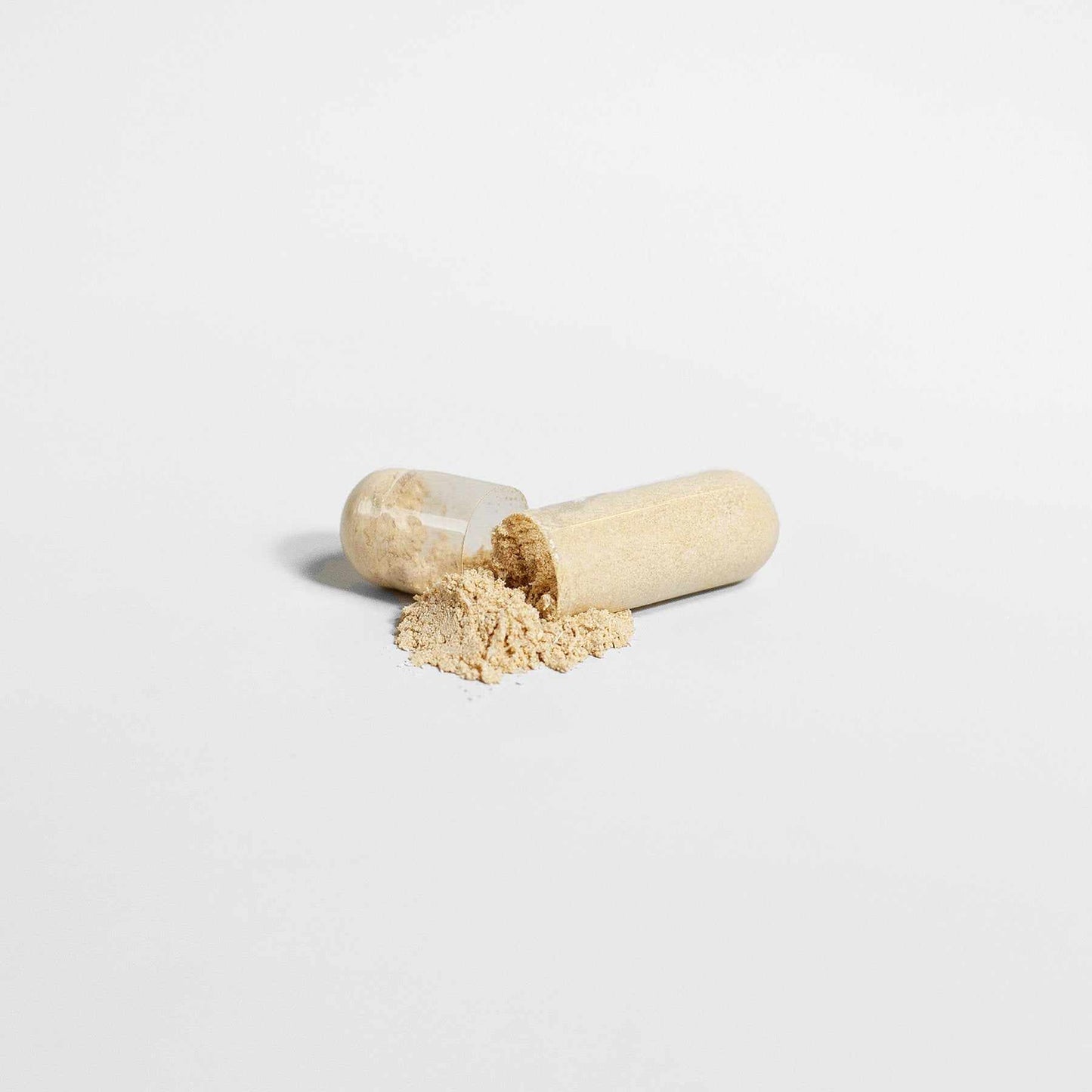 Ashwagandha capsule with powder on white background.