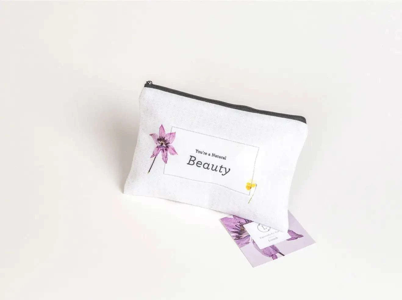 Christmas gift box with a cosmetic bag labeled "You're a Natural Beauty" on a white background.