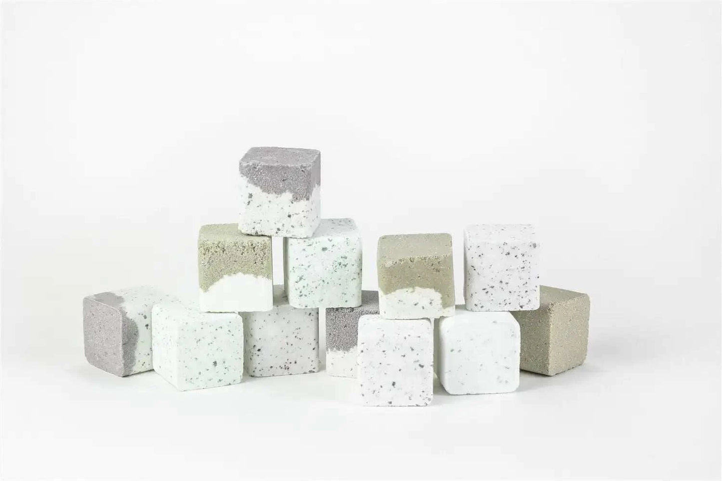 Natural bath steamers in various colors stacked on a white background.