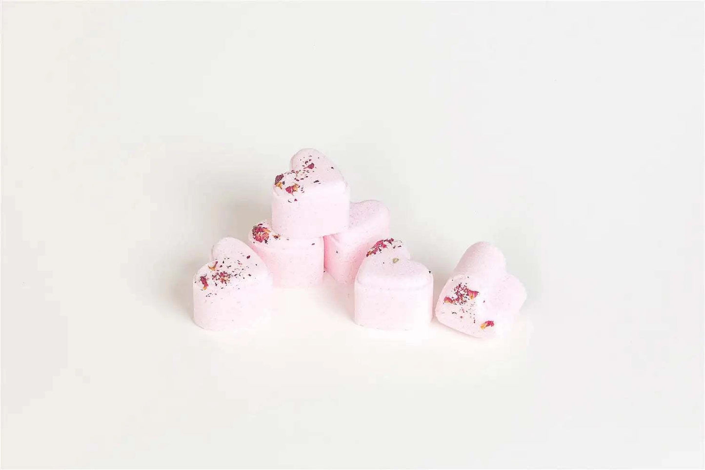 Heart-shaped shower steamers with rose petals, part of a natural skincare gift set for new moms.
