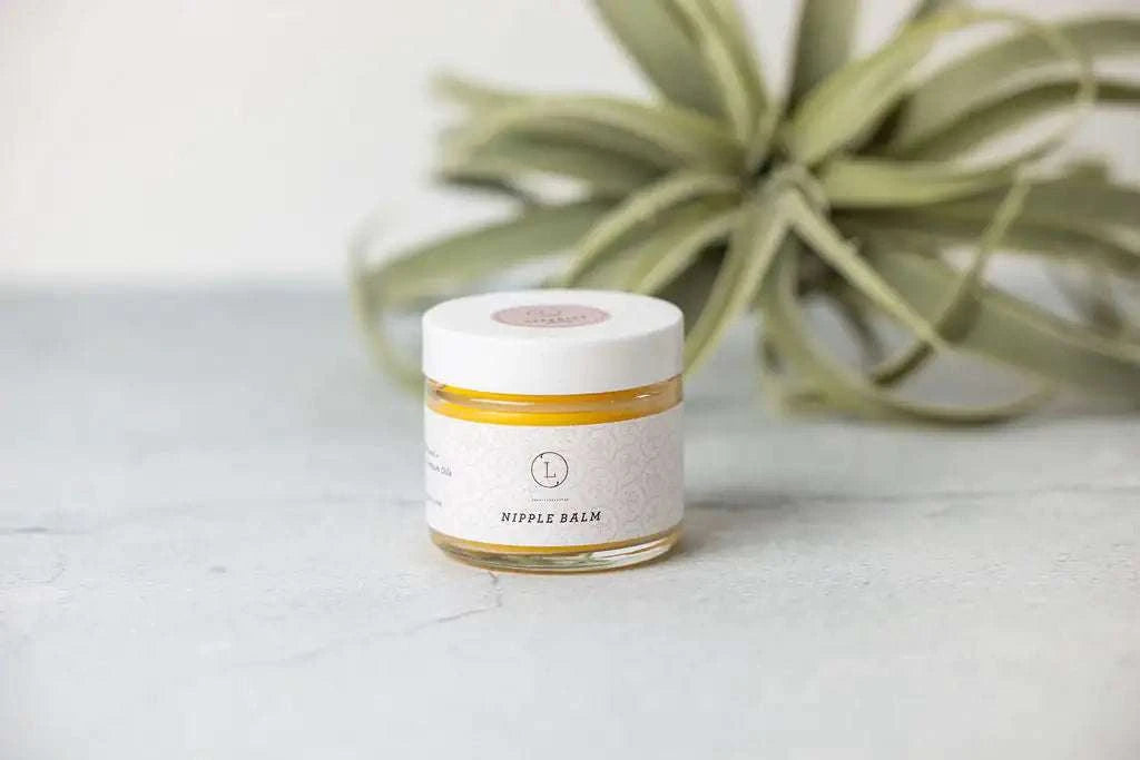 Nipple balm from Pregnancy Gift Box with green plant in background.