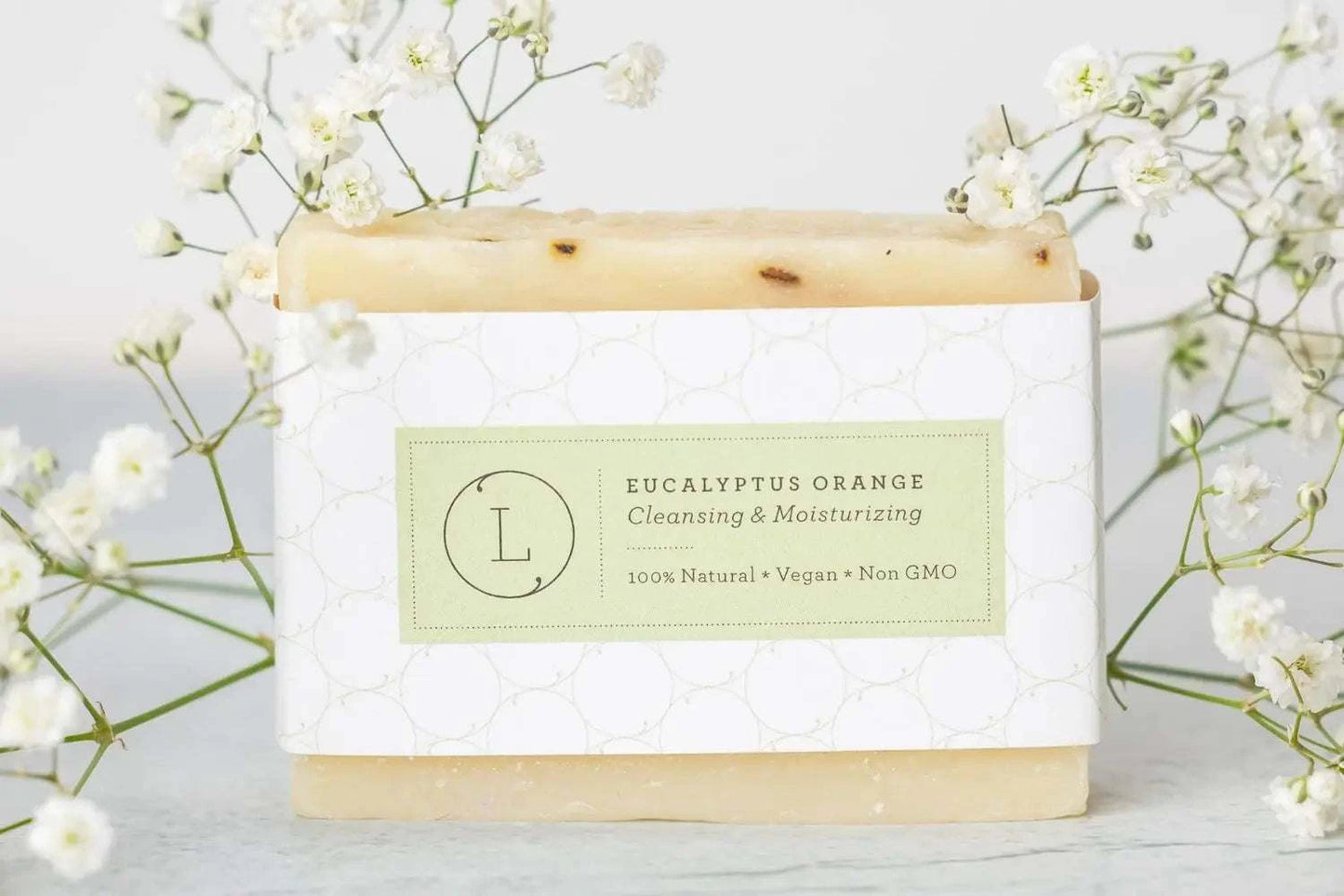 Eucalyptus orange soap bar with natural ingredients and floral decoration.