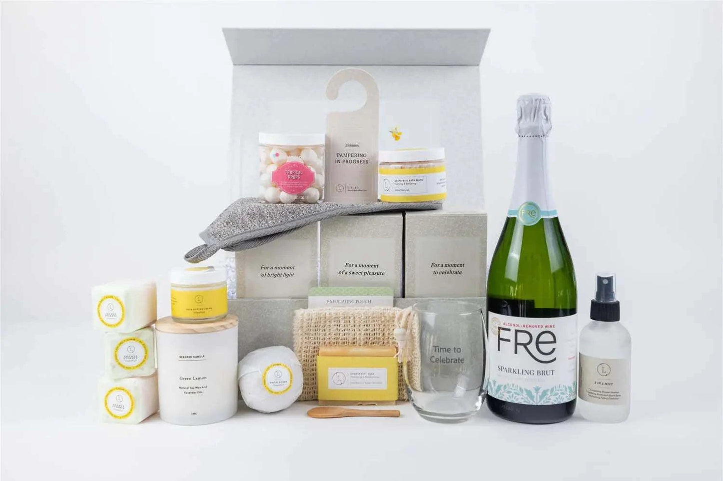 Congratulations gift basket featuring celebratory items like a bottle, wine cup, scented candle, and various grapefruit-scented bath products in an elegant gift box.