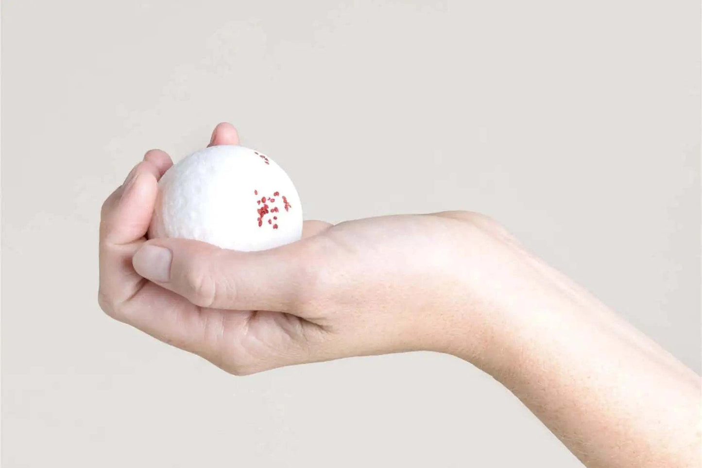 Grapefruit bath bomb in hand from a congratulatory gift basket.
