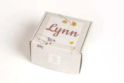 Christmas gift box for cozy nights with personalized name on lid and floral design.
