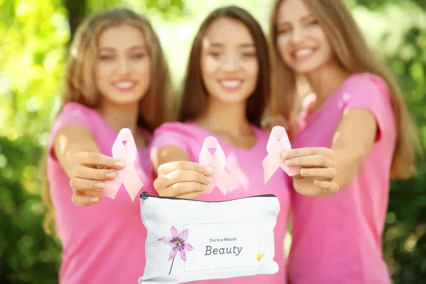 Breast Cancer Awareness Gift Box with pink ribbon and natural beauty products displayed by women in pink shirts.