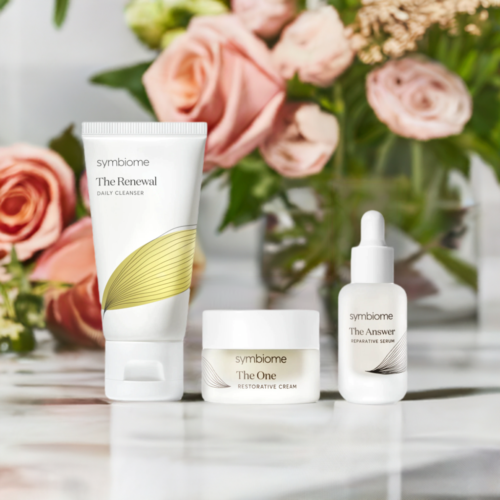 Kate Hudson's Kit - Skincare Essentials by Symbiome with cleanser, serum, and moisturizer, surrounded by pink roses.