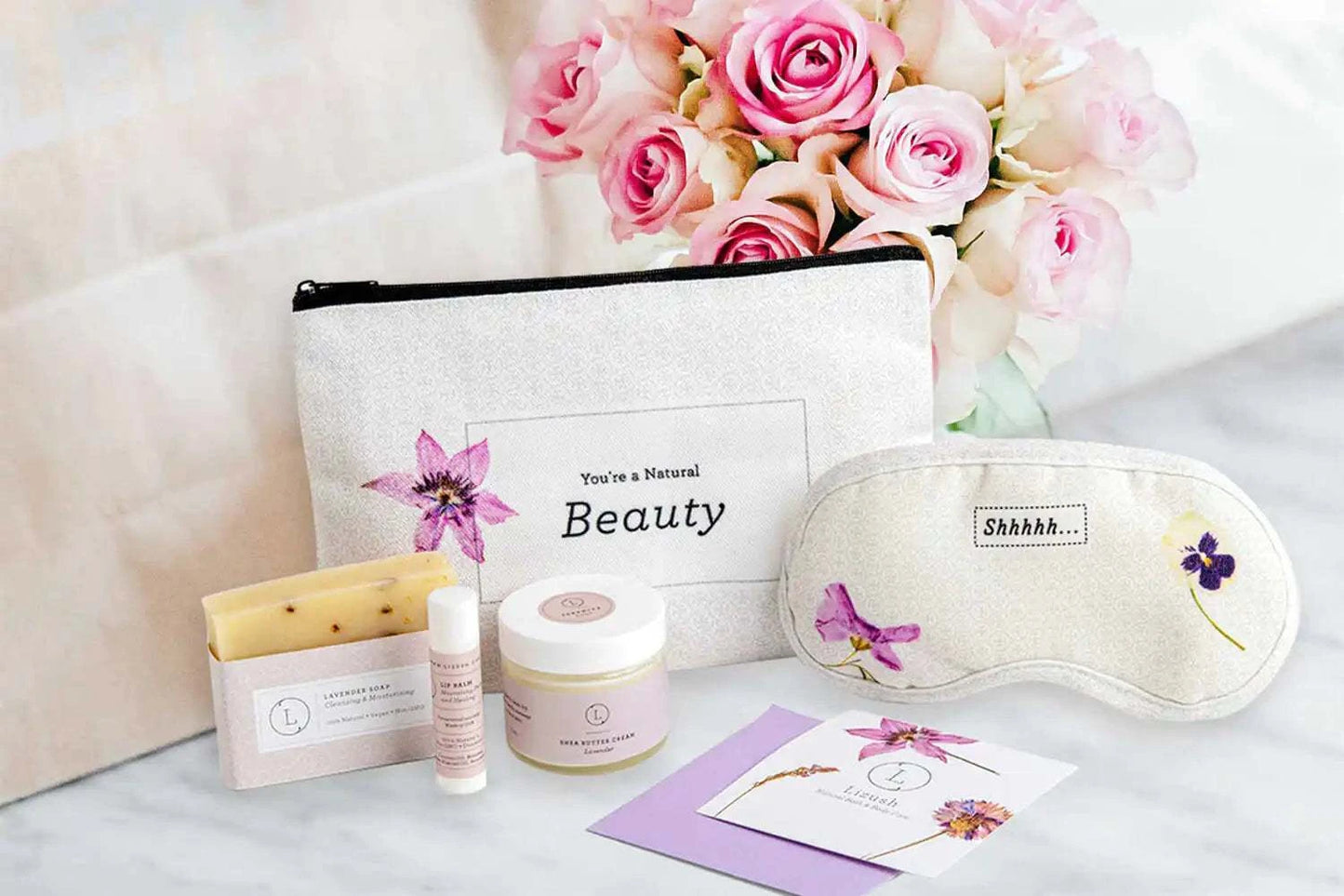Floral-themed cosmetic bag gift set with lavender products and eye mask, ideal for travel and relaxation.