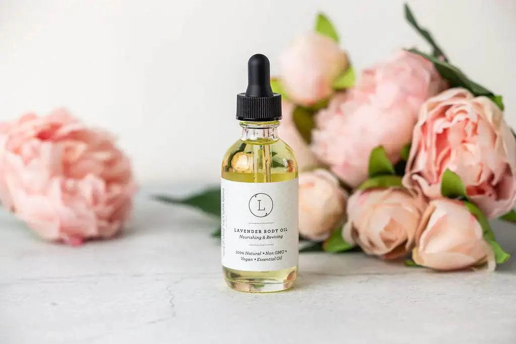 Lavender body oil bottle with dropper, surrounded by pink roses on a light background.